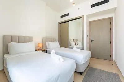 two beds in a room with white walls at Spacious 2 Bedroom in JVC with pool & gym access in Dubai