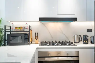 a kitchen with a stove and a microwave at Spacious 2 Bedroom in JVC with pool & gym access in Dubai