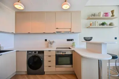 a kitchen with a stove and a dishwasher at Casa Bouclé An Urban sanctuary in DIFC 1BR in Dubai