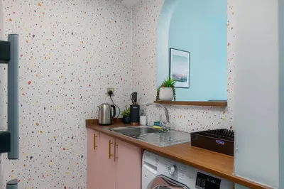 a kitchen with a sink and a washing machine at White Sage Renovated Studio Nxt to Metro in Dubai