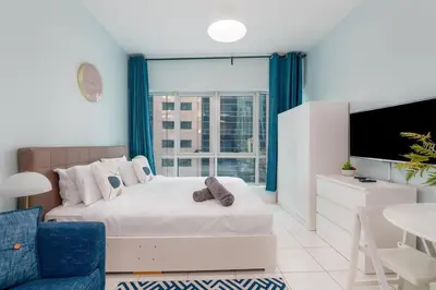 a bedroom with a bed and a large window at White Sage Renovated Studio Nxt to Metro in Dubai