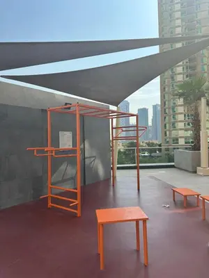 awning with benches and tables on top of a building at Spacious 1 BHK in Marina Heights in Dubai
