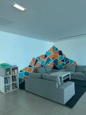 a living room with a couch and a colorful wall at Spacious 1 BHK in Marina Heights in Dubai