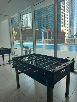a large billiard table in a building with a pool at Spacious 1 BHK in Marina Heights in Dubai