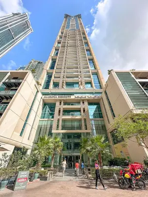 a tall building with people walking in front of it at Spacious 1 BHK in Marina Heights in Dubai