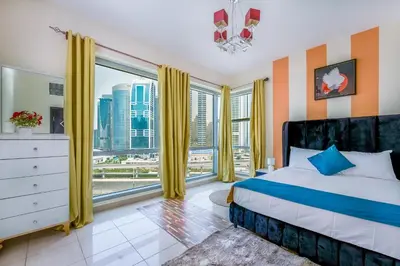 a bedroom with a bed and a large window at Luxurious 2BR in Dubai Marina next to metro in Dubai
