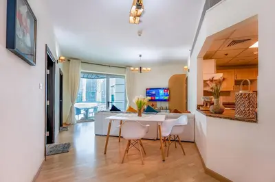 a kitchen and living room with a table and chairs at Luxurious 2BR in Dubai Marina next to metro in Dubai
