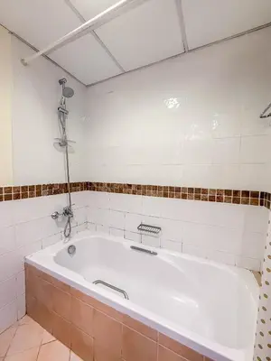 a bath tub in a bathroom with a tiled wall at Luxurious 2BR in Dubai Marina next to metro in Dubai