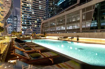 a swimming pool with chaise lounges in a city at Lusso Hometels Missoni Business Bay in Dubai