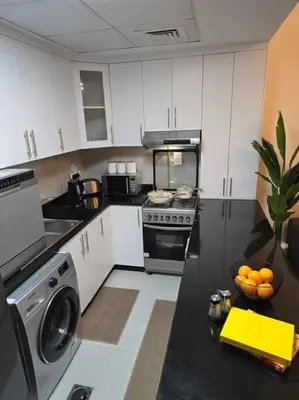 a kitchen with a sink and a stove top oven at Modern Studio Apartment in JVC, behind Circle Mall in Dubai