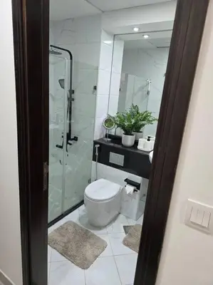 a bathroom with a toilet and a glass shower at Modern Studio Apartment in JVC, behind Circle Mall in Dubai
