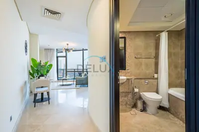 a bathroom with a toilet and a tub and a sink at Lively Studio in Sky Gardens, DIFC by Deluxe Holiday Homes in Dubai