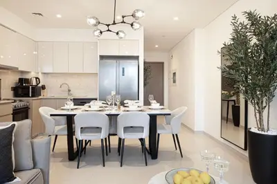 a kitchen and dining room with a table and chairs at BURJ ROYALE - Luxurious Two-Bedroom apartment in DOWNTOWN, Burj Khalifa view POOL in the building, 5-min walk to Dubai Mall & Dubai Fountains in Dubai
