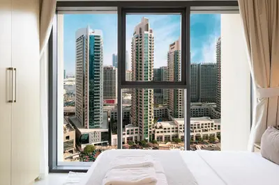 a bedroom with a large window with a view of the city at BURJ ROYALE - Luxurious Two-Bedroom apartment in DOWNTOWN, Burj Khalifa view POOL in the building, 5-min walk to Dubai Mall & Dubai Fountains in Dubai