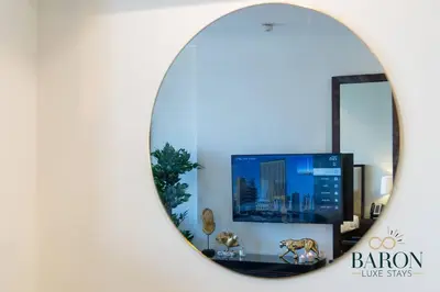 a mirror reflecting a living room with a tv at The Modern in Dubai
