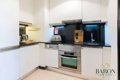 a kitchen with white cabinets and stainless steel appliances at The Modern in Dubai