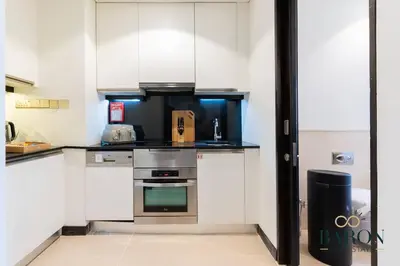 a kitchen with white cabinets and stainless steel appliances at The Modern in Dubai