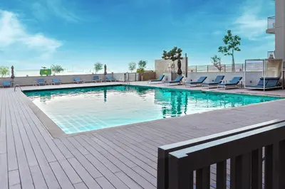 a swimming pool with lounge chairs in a building at Modern 1br Oasis in Sobha Creek Vista A, MBR City - Allsopp & Allsopp in Dubai