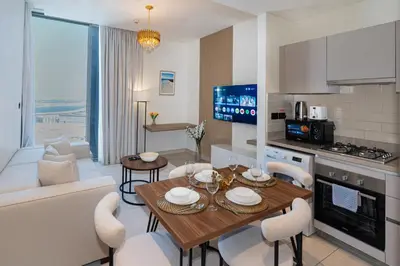 a kitchen and living room with a table and chairs at Modern 1br Oasis in Sobha Creek Vista A, MBR City - Allsopp & Allsopp in Dubai