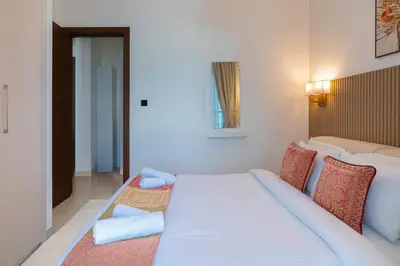 a bedroom with a large bed with blue pillows at Modern 1br Oasis in Sobha Creek Vista A, MBR City - Allsopp & Allsopp in Dubai