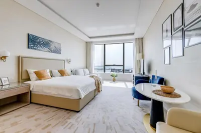 a hotel room with a bed and a table at Luxury Palm Tower Studio Apartments with Pool and Fantastic Sea View in Dubai