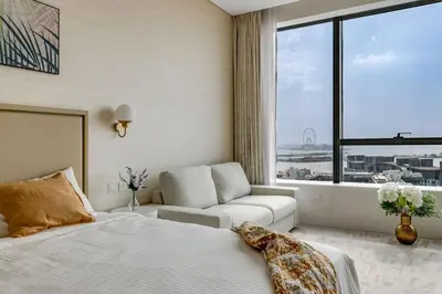 a bedroom with a bed and a couch and a window at Luxury Palm Tower Studio Apartments with Pool and Fantastic Sea View in Dubai