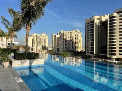 a large swimming pool in a city with tall buildings at Luxury Palm Tower Studio Apartments with Pool and Fantastic Sea View in Dubai