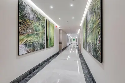 a hallway with large paintings on the walls at Luxury Palm Tower Studio Apartments with Pool and Fantastic Sea View in Dubai