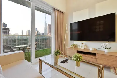 a living room with a tv and a large window at Amazing 1BR APT with Burj Khalifa Views in Dubai