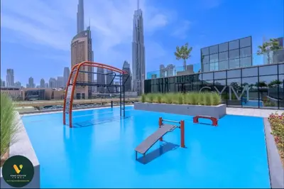 a swimming pool with a slide in a city at Vogue Downtown Views II with Direct Access to Dubai Mall Via a Climate Controlled Bridge, One Bedroom Apartment with Balcony and City View in Dubai