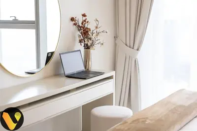 a laptop sitting on a desk in front of a mirror at Vogue Downtown Views II with Direct Access to Dubai Mall Via a Climate Controlled Bridge, One Bedroom Apartment with Balcony and City View in Dubai