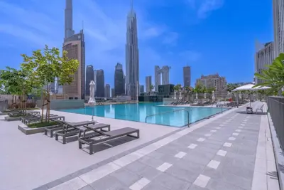 a swimming pool with a city skyline in the background at Vogue Downtown Views II with Direct Access to Dubai Mall Via a Climate Controlled Bridge, One Bedroom Apartment with Balcony and City View in Dubai