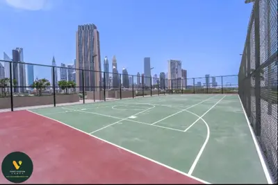 a tennis court with buildings in the background at Vogue Downtown Views II with Direct Access to Dubai Mall Via a Climate Controlled Bridge, One Bedroom Apartment with Balcony and City View in Dubai