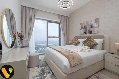 a bedroom with a large bed and a large window at Vogue Downtown Views II with Direct Access to Dubai Mall Via a Climate Controlled Bridge, One Bedroom Apartment with Balcony and City View in Dubai
