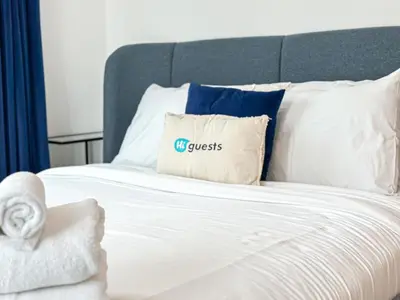 a bed with a comforter with a guess pillow on it at Near Metro & Tram 2bed Dubai Marina Close To Jbr! in Dubai