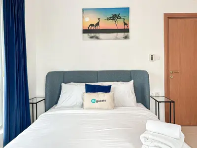 a bed with a blue headboard with a pillow on it at Near Metro & Tram 2bed Dubai Marina Close To Jbr! in Dubai