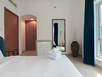 a bedroom with a white bed and a mirror at Near Metro & Tram 2bed Dubai Marina Close To Jbr! in Dubai