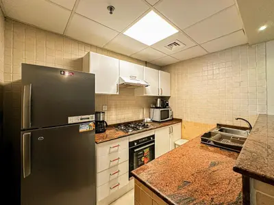 a kitchen with a refrigerator and a stove top oven at Near Metro & Tram 2bed Dubai Marina Close To Jbr! in Dubai