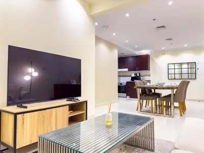 a living room with a large tv and a table at 1BHK in Business Bay near metro in Dubai
