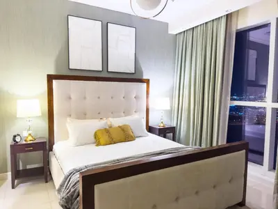 a bedroom with a bed with two night stands and two lamps at 1BHK in Business Bay near metro in Dubai