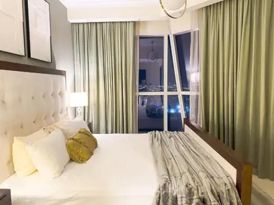 a bedroom with a white bed with a large window at 1BHK in Business Bay near metro in Dubai