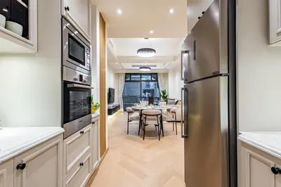 a kitchen and dining room with a table and a refrigerator at Upgraded 1BR Retreat with Iconic Burj Khalifa Views in Dubai