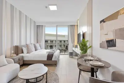 a bedroom with a bed and a living room at Perfect Getaway modern Studio in Luma 22 - JVC in Dubai