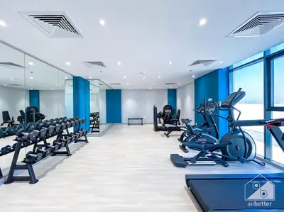 a gym with treadmills and elliptical machines at Bright Studio in Azizi Riviera Perfect City Escape in Dubai
