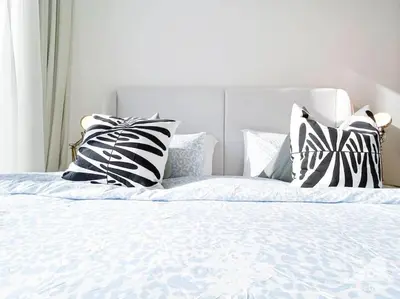 a bed with black and white pillows on it at Bright Studio in Azizi Riviera Perfect City Escape in Dubai