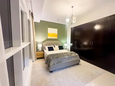 a bedroom with a bed and a green wall at Luxury apartment in Business bay 5 people in Dubai