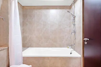 a bathroom with a bath tub and a shower at Silkhaus Sky Gardens Chic Studio in DIFC Living in Dubai