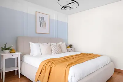 a bedroom with a large bed with a yellow blanket on it at Silkhaus Comfort Studio at Sky gardens-DIFC in Dubai