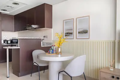 a kitchen with a table and chairs in a room at Silkhaus Comfort Studio at Sky gardens-DIFC in Dubai