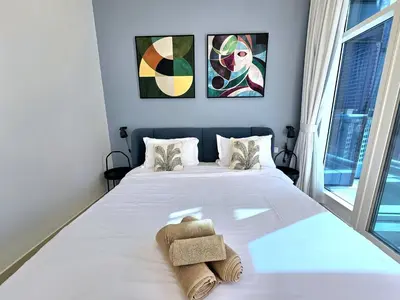 a bedroom with a white bed with towels on it at SUNRISE HOMES - 2 BR with Panoramic Marina Views in Dubai